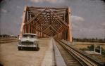 <span class="caption-caption">Burdekin Bridge with car</span>, c1950s. <br />Slide, collection of <span class="caption-contributor">Beth Snewin</span>.