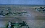 <span class="caption-caption">Magistrate's residence in foreground. He dug a well in his back yard and erected a windmill to pump water before electric motors were introduced, Normanton</span>, 1973. <br />Slide, collection of <span class="caption-contributor">John Hindmarsh</span>.