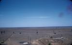 <span class="caption-caption">View across the Mitchell Grass Plains from the top of the Hospital Hill bore-water storage tower; old derrick in right-foreground is a remnant from early petroleum exploration activities on Hospital Hill, Roma</span>, c1959. <br />Slide, collection of <span class="caption-contributor">Patrick Conaghan</span>.
