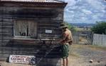 <span class="caption-caption">Silverspur post office, with old bank sign leaned against wall</span>, 1966. <br />Slide, collection of <span class="caption-contributor">Ruth Read</span>.