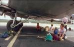 <span class="caption-caption">Sitting in the only shade, Lockhart River airport</span>, 1982. <br />Slide, collection of <span class="caption-contributor">Ruth Read</span>.